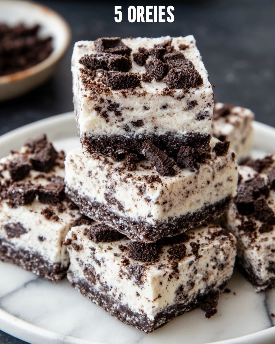 The image shows a close-up of four stacked dessert squares on a white plate, placed on a white marbled surface. Each square has two visible layers: the base layer is creamy white with lots of small dark cookie crumbs sprinkled evenly throughout, giving it a speckled texture, while the top layer has larger dark cookie chunks scattered over the surface. The squares look soft yet firm, with a slightly crumbly texture along the edges. The cookies appear to be chocolate with a rich dark color contrasting vividly against the white cream base. Photo taken with an iphone --ar 4:5 --v 7