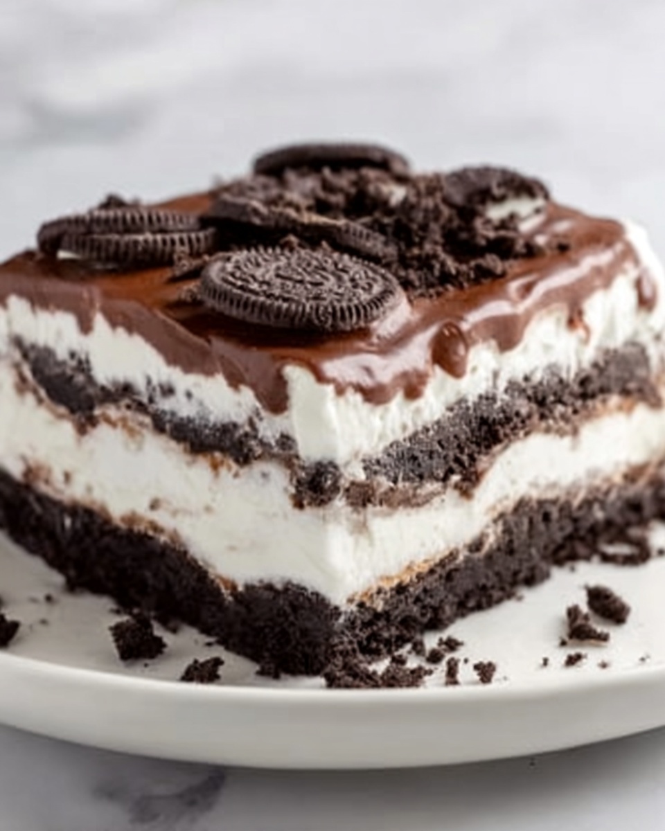 The image shows a multi-layered dessert on a white plate, placed on a white marbled surface. The dessert has four clear layers: a bottom layer of dark chocolate cookie crumbs, a thick smooth white creamy layer above it, followed by a dark chocolate filling layer, then a top white creamy layer that looks light and fluffy. The dessert is topped with crushed dark chocolate cookies, some pieces whole, adding texture and contrast in black and white colors. Photo taken with an iphone --ar 4:5 --v 7