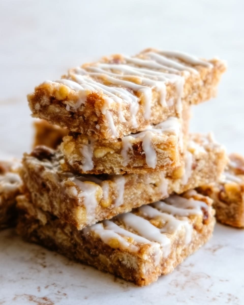 The image shows a stack of six crunchy granola bars placed closely together on a white marbled surface. Each bar is rectangular with a rough texture filled with visible oats, nuts, and small bits of dried fruit. The top layer has a light, glossy drizzle of white icing that adds a soft contrast to the golden brown color of the bars. The bars look thick and chewy, with nuts embedded in the middle layers, giving a mix of beige and light brown tones. The overall look is natural and homemade, showing the sweet and nutty texture clearly. Photo taken with an iphone --ar 4:5 --v 7