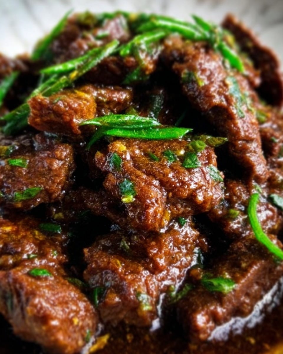 The image shows a close-up of cooked beef strips covered in a dark brown sauce, garnished with small bright green chopped herbs scattered on top. The beef looks tender and glossy, with a rich texture, and the herbs add a fresh contrast to the dish. The background is a white marbled texture. photo taken with an iphone --ar 4:5 --v 7