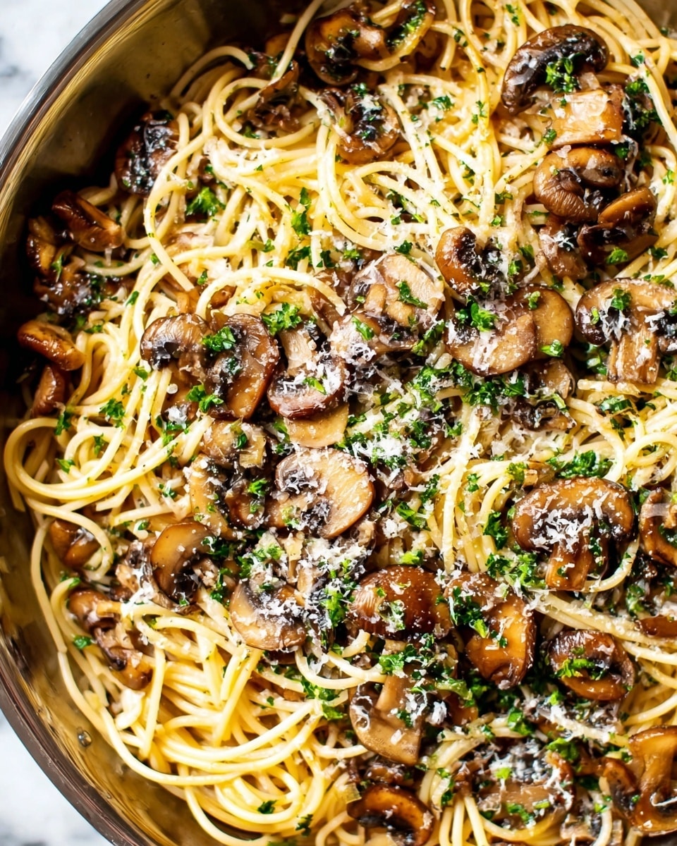 A close-up view of a dish of spaghetti mixed with sautéed mushroom slices, all layered evenly with the light brown noodles intertwined with glossy, dark brown mushrooms scattered throughout. The pasta is topped with a sprinkling of finely grated white cheese and small bits of bright green chopped parsley, adding color and texture contrast. The meal is served in a white bowl placed on a white marbled surface, enhancing the natural colors of the dish. Photo taken with an iphone --ar 4:5 --v 7