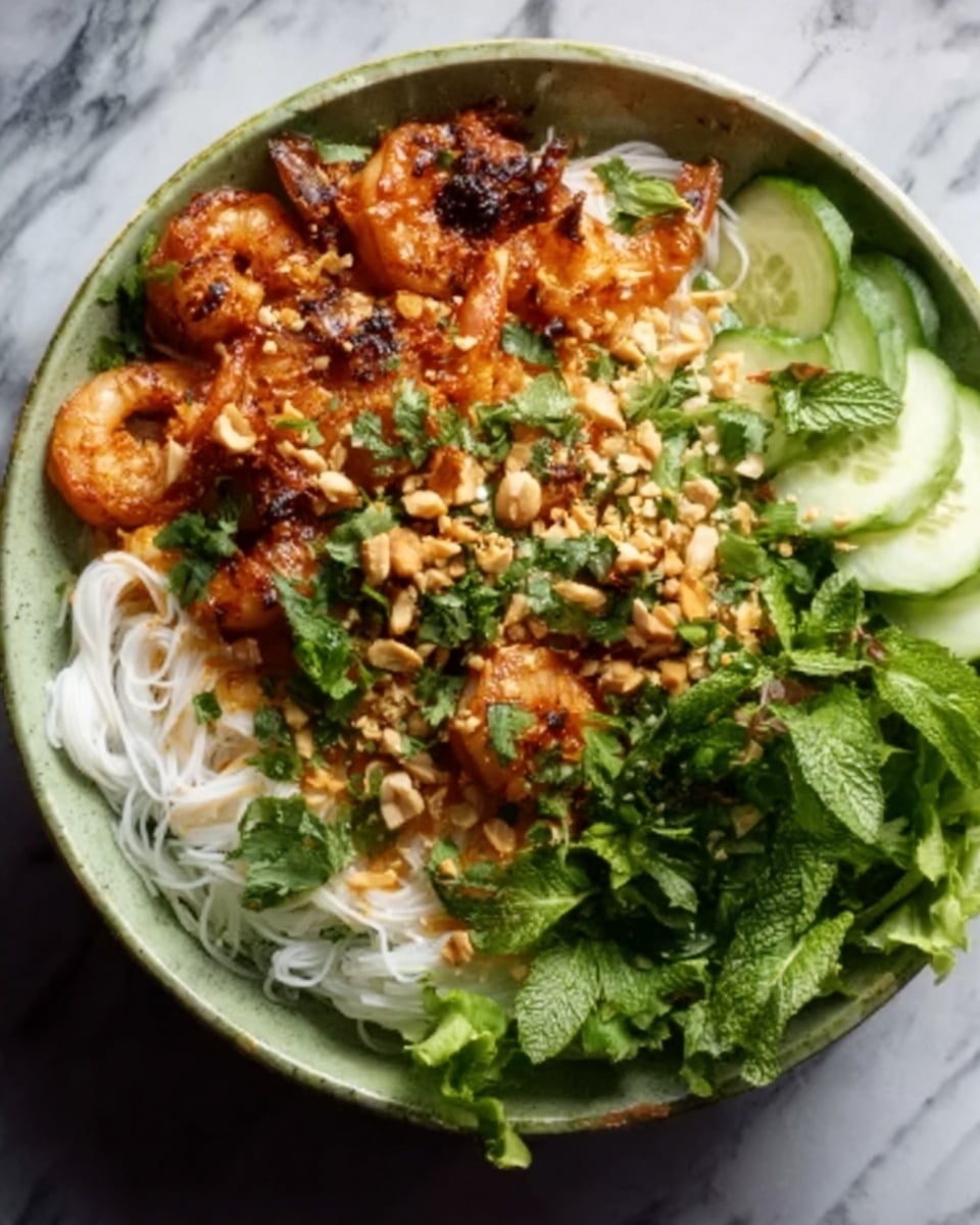 A white bowl filled with translucent rice noodles at the bottom, topped with a layer of cooked shrimp covered in a rich, reddish-brown sauce with small white crushed peanuts sprinkled over. Fresh green cilantro leaves and chopped green herbs are scattered on one side, next to some fresh green mint leaves, a slice of cucumber with pale green color and a few pieces of leafy lettuce on the other side. The dish has a mix of smooth, shiny, and crunchy textures from the sauce, peanuts, and fresh herbs. The bowl is placed on a white marbled surface. Photo taken with an iphone --ar 4:5 --v 7